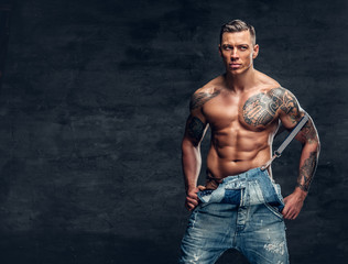 A man with a tattoo on his chest dressed in a jeans.
