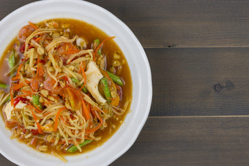 Thai spicy papaya salad on wooden table