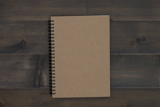 brown notebook on wooden table