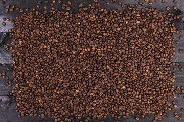 Fototapeta premium Frame of coffee beans on dark wooden background. Top view with copy space