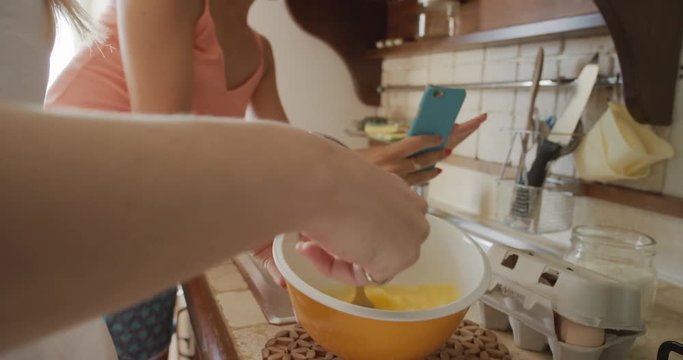 Close up woman hand beating egg Friends making home made Pancakes taking photo using phone sharing on social media