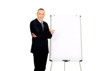 Male executive pointing on flip chart