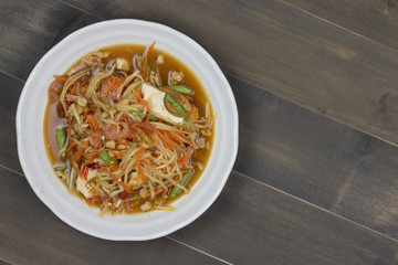 Thai spicy papaya salad on wooden table
