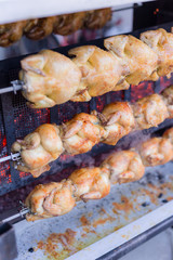 Grillhähnchen auf dem Spieß am Griller