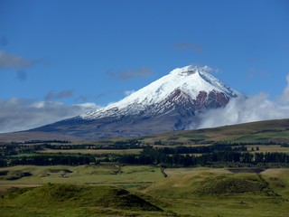 Fototapeta premium Farmland surrounding the active Cotopaxi Volcano on a stunning blue sky day. 