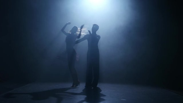 Dance element from the jive, silhouette couple ballroom. Smoke background