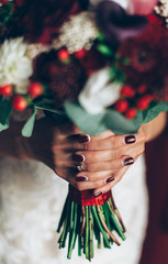 Fototapeta na wymiar wedding red bouquet in hands of the bride