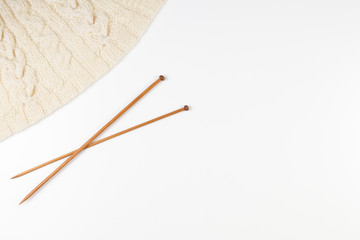 Knitting and pair of wooden knitting needles on white background