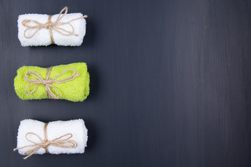 Three different towels are lying on a black background