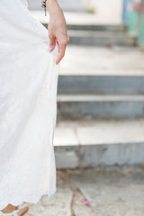 Füße einer Frau mit weißen Kleid in der Altstadt von Athen, Griechenland