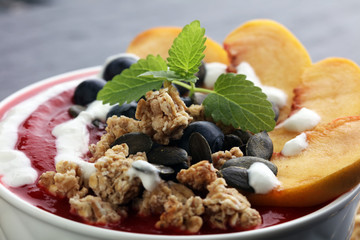 breakfast smoothie bowl with blueberries, peach and granola