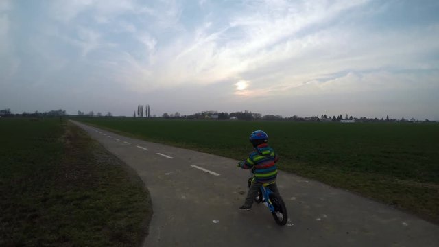 Cute little boy riding a bike.
Boy riding a bike along the cycle path.