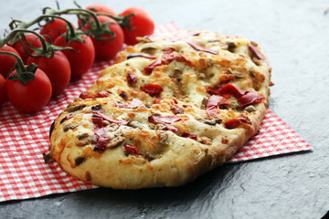 Hot pizza slice with melting cheese on a rustic wooden table.