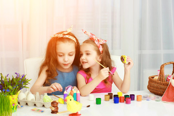 Obraz na płótnie Canvas Two girls painting Easter eggs