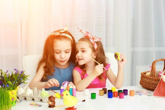 Two girls painting Easter eggs