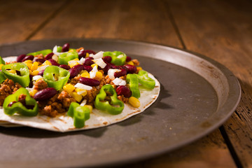 Mexican tortillas with meat, red beans, Jalapeno pepper and onion