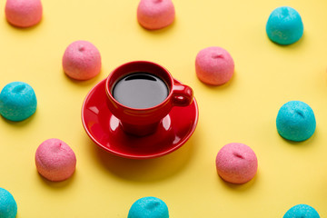 photo of tasty colorful marshmallows and cup of coffee on the wonderful yellow background