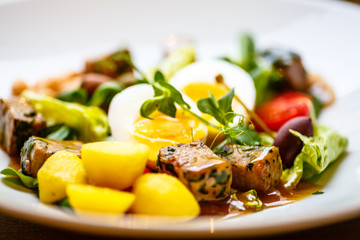 Salad with tuna, potatoes, capers, beans, egg and tomatoes.