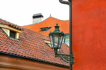 Traditional street lamp and the tiled roofs of Prague