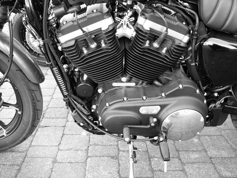 Zweizylinder V2 Motor eines amerikanischen Motorrad Klassiker auf altem Kopfsteinpflaster am Kreativkai am Hafen von Münster in Westfalen im Münsterland, fotografiert in neorealistischem Schwarzweiß