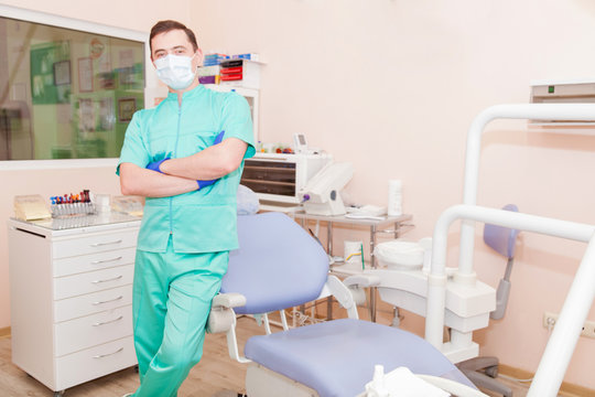 Young male dentist standing in the office