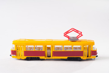 Toy tram in yellow on white background,