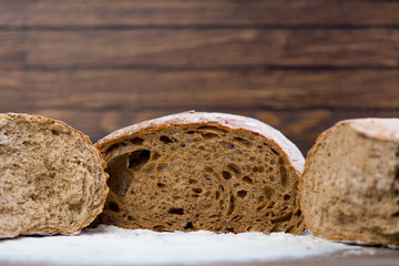photo of tasty fresh bread loaves on the wonderful brown wooden background