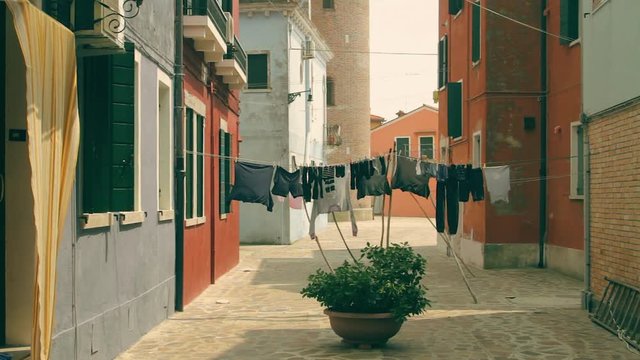 Quiet square in Burano island. Clothesline between colorful houses.