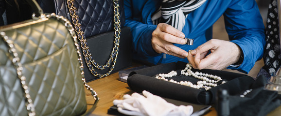 Jeweler examining diamond through loupe © karrastock