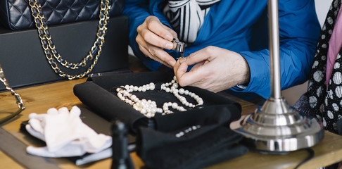 Jeweler examining diamond through loupe © karrastock