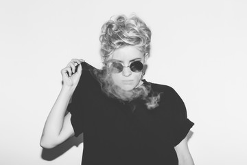 Stylish fashion sexy blonde bad girl in a black t-shirt and rock sunglasses. Dangerous rocky...