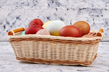 Basket with dyed chicken eggs. Side view of wicker basket. Easter egg design.