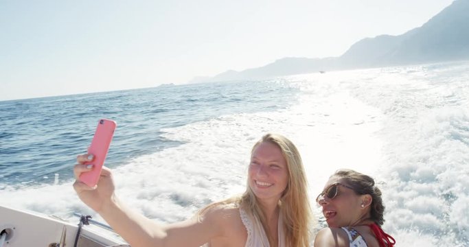 Best friends taking selfie photo Two young Women enjoying sunset on party boat European summer holiday travel vacation adventure in Amalfi Coast Italy