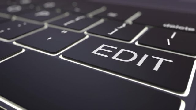 Dolly shot of black luminous computer keyboard and edit key. Conceptual 4K clip