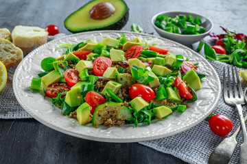 Quinoa tabbouleh salad with avocado, tomatoes, cucumber, green onion. Concept healthy food.