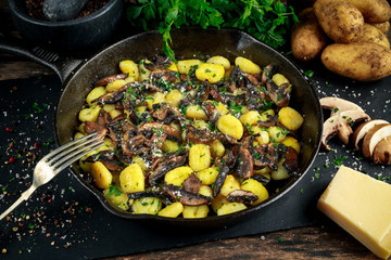 Home made potato gnocchi with mushrooms, chopped parsley and parmesan cheese in iron pan