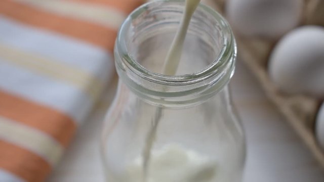 Beim Backen wird Milch in eine Glasflasche gefüllt