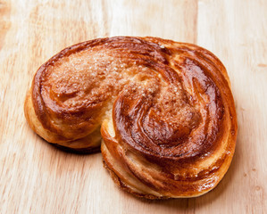Yeast sweet buns in the shape of a heart on an wooden table. Country house style. Authentically.