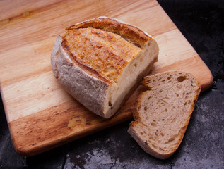 Sliced rye bread on a Board on black baking tray. Country house style. Authentically.