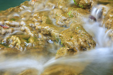 close up waterfall with rock and clear green emerald with blue water for relax feel on summer holiday with plant or lichen in the jungle at Huay Mae Khamin waterfall for fresh nature landscape