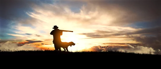 Papier Peint photo Chasser chasseur avec chien au coucher du soleil
