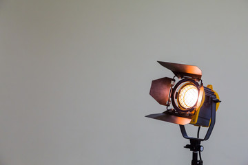 Spotlight with halogen bulb and Fresnel lens. Lighting equipment for Studio photography or videography. - obrazy, fototapety, plakaty