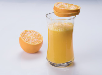 glass of orange juice on white table