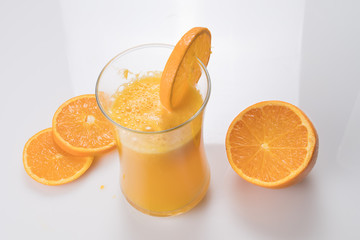 glass of orange juice on white table