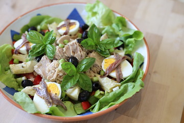 Salad nicoise in a dish on wooden kitchen island