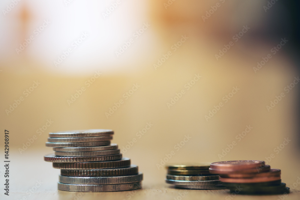 Wall mural coins stack on wooden table with blur background