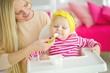 Obraz na płótnie Canvas A woman is feeding a young child 