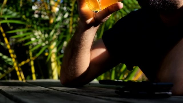 Man picking up beer from table