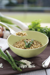 Risotto with Asparagus in ceramic vase on wooden chopping board