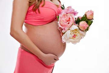 Tummy of a pregnant woman in pink with a pink ribbon on her stomach, a newborn girl